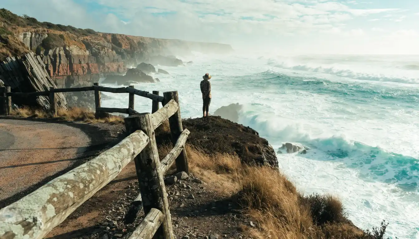 Man pondering on cliff road